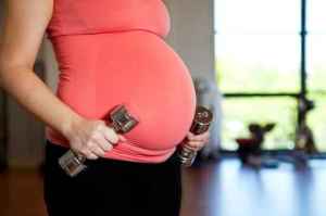 Pregnant woman holding dumbbells