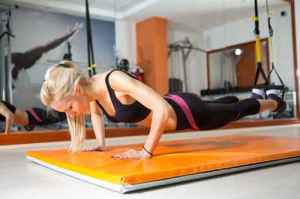 Young woman looking down while doing push-ups