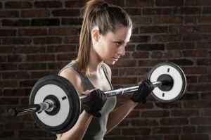 PSweat beautiful girl lifting dumbbells on dark background